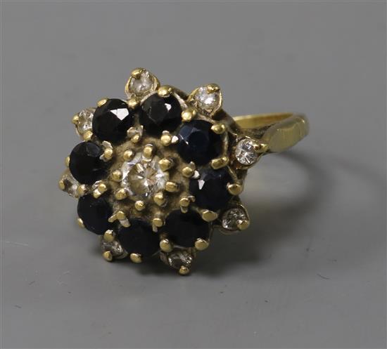 A yellow metal sapphire and diamond cluster ring, size P.